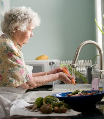Oude vrouw wast eten